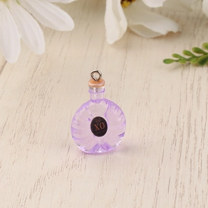 Detail eines Miniatur XO Flaschenanhängers aus violettem Harz mit Metallring für DIY