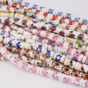 Close-up of assorted cylindrical ceramic beads with vibrant floral prints for DIY jewelry