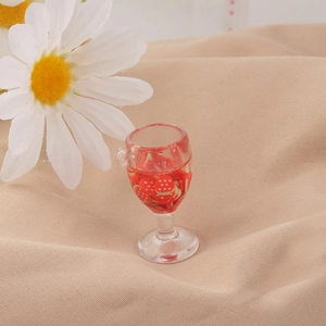 Dettaglio macro di un calice da vino in miniatura con liquido rosso e fragola per il fai da te