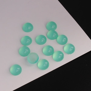 Vue macro de treize cabochons ronds en résine vert raisin translucide pour bijoux DIY