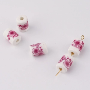 Detail of DIY floral printed ceramic cylinder beads with pink flower patterns for jewelry