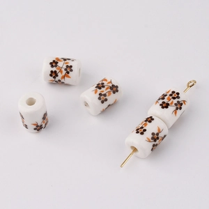 Detailed macro view of cylinder ceramic beads with brown floral print for DIY jewelry making