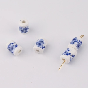 Macro detail of cylindrical blue and white floral ceramic beads for DIY jewelry making