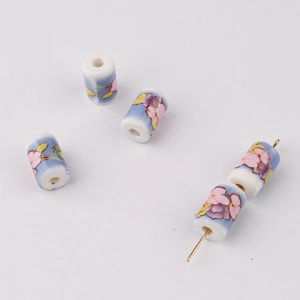Detailed macro view of cylinder ceramic floral beads with blue and purple patterns