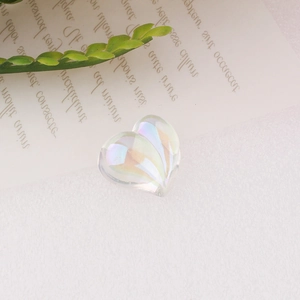 Macro detail of a heart-shaped resin bead with iridescent rainbow AB coating for DIY crafts