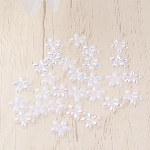Flat lay of iridescent resin five-petal flowers for DIY nail art and phone case decor