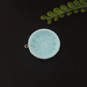 Detail shot of light blue resin woven-texture round charm with golden ring for DIY jewelry