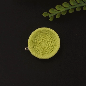 Close-up of a pale green resin mini woven basket charm with metal loop for DIY crafts