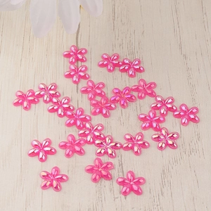 Flatback resin pink flowers with AB luster finish for DIY crafts on wood background