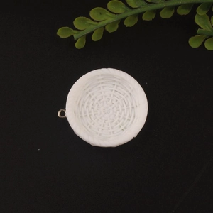 Macro detail of white resin basket charm with intricate woven texture and gold metal ring