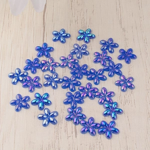 Detailed close-up of blue AB resin flower charms for DIY crafts and nail art decor