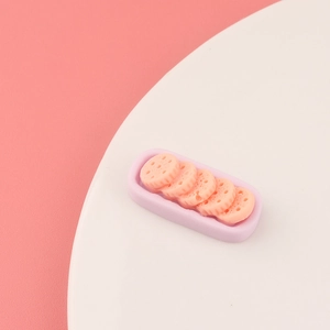 Detailed macro view of resin purple food tray with pink miniature biscuit charms