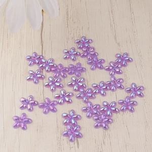 Macro shot of purple resin flower beads with AB iridescent coating for DIY nail art