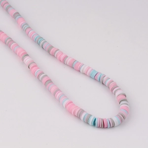 Close-up of pastel macaron color heishi clay beads arranged in a rhythmic pattern