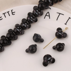 Dettaglio di simpatiche perline di ceramica nera a forma di topo per gioielli fai-da-te