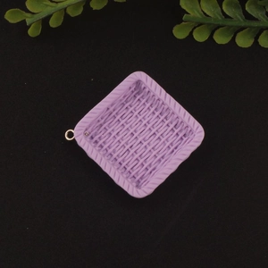 Macro view of light purple square resin charm with woven texture and gold metal ring