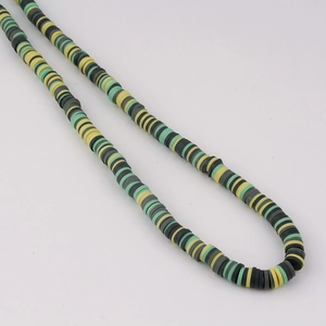 Detail of colorful polymer clay Heishi beads in green, yellow, and charcoal for DIY jewelry