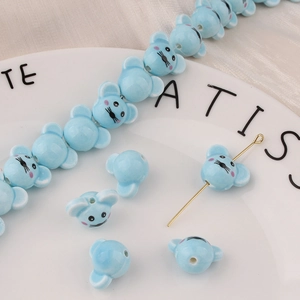 Dettaglio di perla in ceramica azzurra a forma di topo per creazione di gioielli