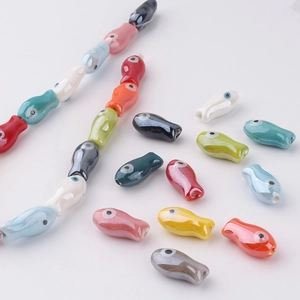 Macro view of colorful ceramic fish beads with glossy glazed finish for DIY jewelry