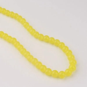 Détail de perles rondes en verre jaune citron de 8mm pour la création de bijoux DIY