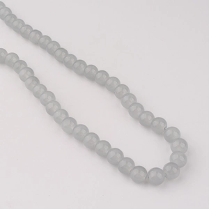 Vue macro de perles en verre gris clair de 8mm pour la création de bijoux DIY