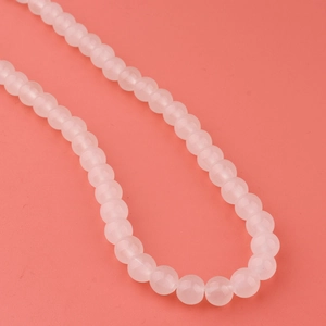 Gros plan de perles en verre rose de 8mm pour la création de bijoux et colliers DIY
