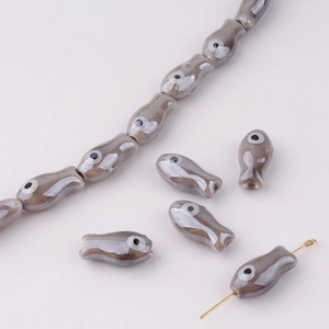 Macro detail of handmade vintage ceramic fish beads for DIY jewelry making and necklaces