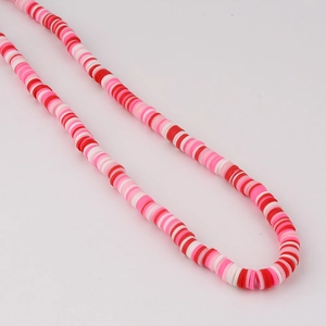 Macro detail of red pink and white polymer clay heishi beads for DIY jewelry making