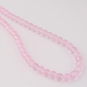 Gros plan de perles en verre rose translucide de 8 mm pour la création de bijoux DIY