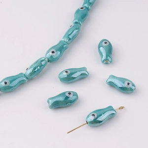 Macro detail of turquoise handmade fish-shaped ceramic beads for DIY jewelry making