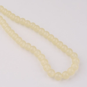 Vue macro de perles en verre crème de 8mm pour la création de bracelets et colliers DIY