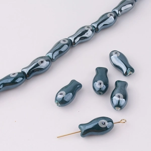 Macro detail of fish-shaped beads with evil eye pattern for DIY jewelry making