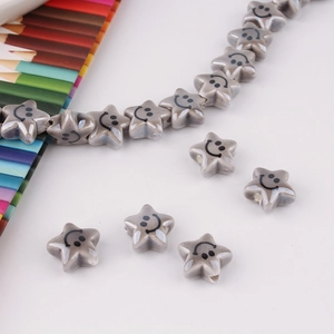 Macro shot of grey ceramic star beads with smiley faces for DIY jewelry making
