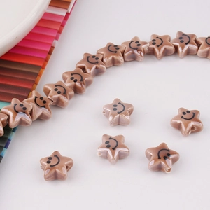 Macro shot of warm brown star-shaped ceramic beads with black smiley faces for DIY jewelry