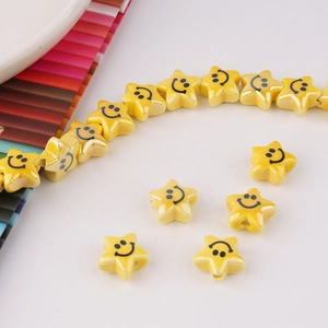 Macro view of a yellow ceramic star bead with a smiley face for DIY handmade jewelry