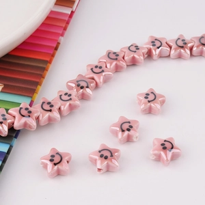 Macro shot of pink ceramic star beads with smiley faces for DIY jewelry making