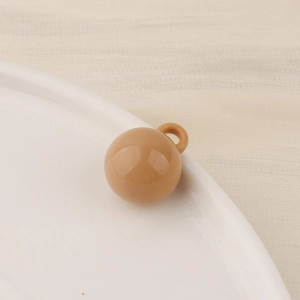 Close-up of caramel round resin pendant with integrated loop for DIY jewelry crafting
