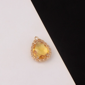 Detalle de colgante de cristal en gota con marco de filigrana dorada para creación de joyería