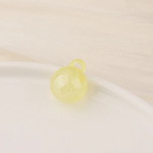 Macro shot of a yellow translucent resin ball charm for DIY jewelry making