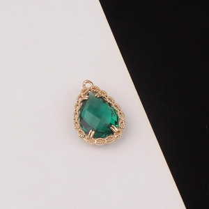 Detalle de colgante de cristal verde esmeralda con marco dorado vintage trabajado