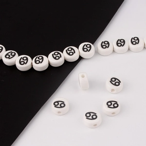 Macro shot of white round ceramic beads with black zodiac sign for DIY bracelet jewelry