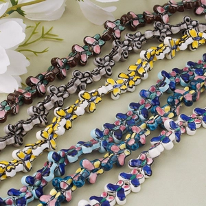 Close-up of hand-painted butterfly ceramic beads for DIY jewelry making in various colors