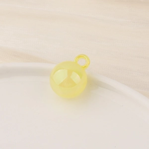 Macro shot of bright yellow translucent resin ball charm with integrated hanging loop