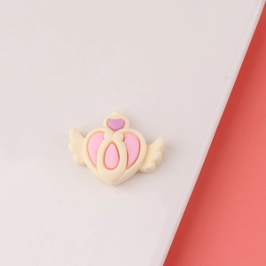 Close-up of heart-shaped winged resin charm for DIY hair clips and craft decoration