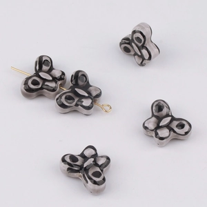 Close-up of butterfly-shaped ceramic beads with hand-painted glaze for DIY jewelry