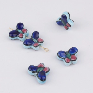 Close-up of colorful hand-painted butterfly ceramic beads with DIY golden pins