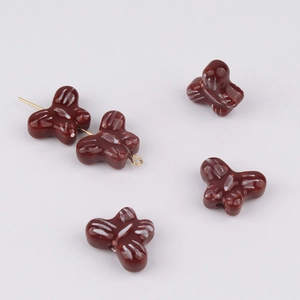 Close-up of brown butterfly ceramic beads with white stripes for DIY jewelry making