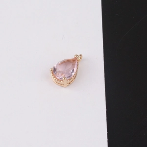 Detailed close-up of a pink pear-cut crystal pendant with a gold plated setting and bail