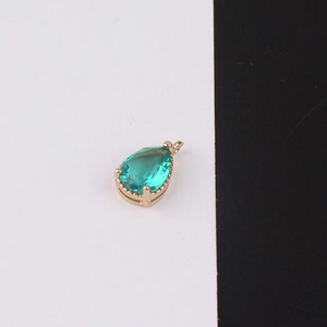 Detailed view of pear-shaped green crystal pendant with gold-plated bezel for DIY jewelry