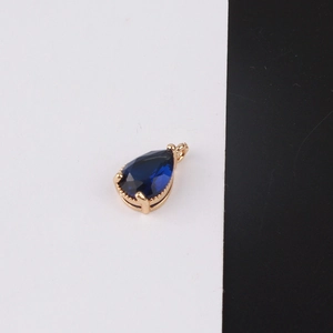 Detail of tear-drop shaped dark blue crystal pendant with gold-plated beaded edge frame